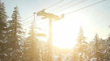 leerer Skilift. Sessellift-Silhouette auf einem hohen Berg über dem Wald bei Sonnenuntergang video