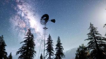 retro windmill in mountain forest with stars. hyperlapse video