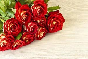 Red roses on white wooden background with copy space photo