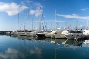 Marina with yachts and boats reflected on the water