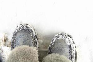 Warm winter women's boots of gray color with fur on a background of snow. photo