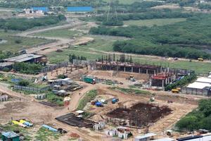 imagen aérea de drones de un sitio de construcción. equipo pesado está nivelando la tierra, moviendo y aplanando el suelo de arcilla roja. foto