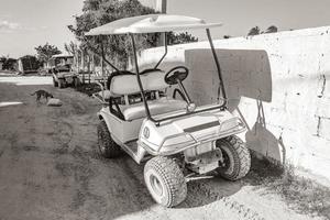 Golf cart buggy cars carts muddy street village Holbox Mexico. photo