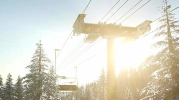 leerer Skilift. Sessellift-Silhouette auf einem hohen Berg über dem Wald bei Sonnenuntergang video