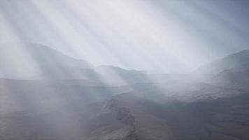 rayos de sol contra el telón de fondo de las montañas video