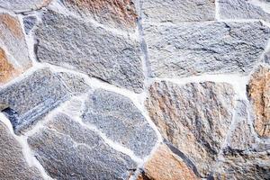 textura de piedra Muro gris oscuro y piedra rojiza de piedra natural. de cerca. fondo de pared de escombros. foto