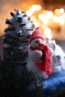 New Year's composition with hand-made snowman with a red knitted scarf and hat. photo