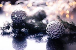 Christmas toys, silver balls on Christmas tree branch. Bokeh background Christmas decoration. Copy space photo