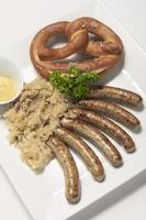 sausage with sauerkraut and pretzel traditional german food meal photo