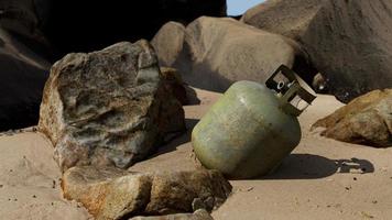 old cooking gas cylinder on sand beach photo