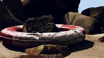 old Life Buoy on sand in sunset video