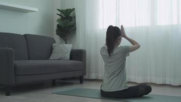 linda mulher asiática fazendo ioga e recreação em casa. as mulheres jogam ioga para fortalecer o abdômen e perder peso. conceito saudável e recreativo. video