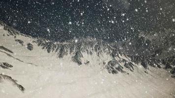 nevando forte, focado nos flocos de neve, montanhas ao fundo