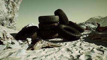 Old tire on the seashore and pollution of nature photo