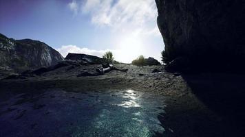 spiaggia sabbiosa nella baia circondata da ripide montagne al tramonto video