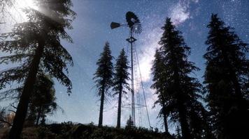 retro windmill in mountain forest with stars. hyperlapse video