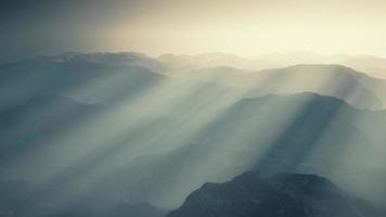 black rocky mountain silhouette in deep fog photo