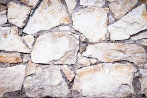 Stone texture. Dark grey and brownstone wall made of natural stone. Close-up. Rubble wall background. photo