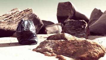black plastic garbage bag full of trash on the beach video