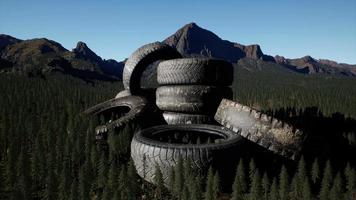 concept de pollution de l'environnement avec de gros vieux pneus dans la forêt de montagne video