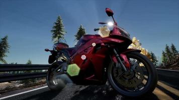 sportbike on tre road in forest with sun beams video