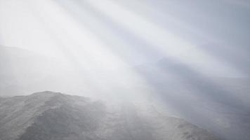 rayos de sol contra el telón de fondo de las montañas video