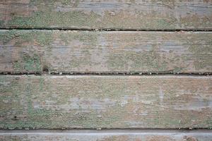 la pared está hecha de tablas viejas con restos de pintura verde foto