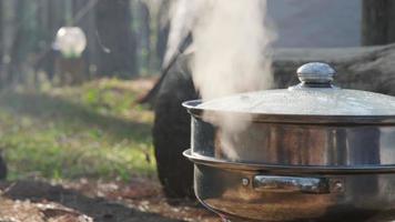 matlagning i naturen camping utomhus. spis förbereda frukostpicknick på en bärbar lägerspis. campingens livsstil. video