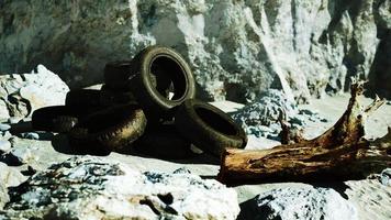 old tires overgrown embedded in the sand photo