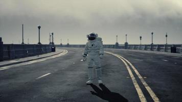 astronaut walks in the middle of a road photo