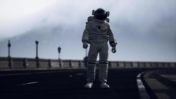 astronaut walks in the middle of a road photo