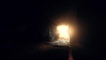sunlight filters into a wet stone cave photo