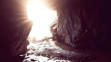 impresionante paisaje de brillantes rayos de sol cayendo dentro de una cueva iluminando foto