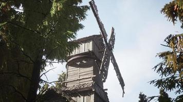 old traditional wooden windmill in the forest photo