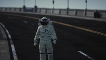 astronaut walks in the middle of a road photo