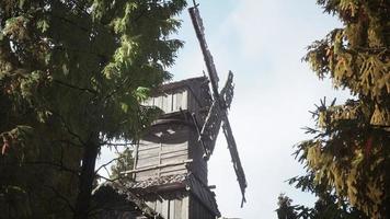 old traditional wooden windmill in the forest photo