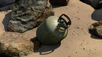 old cooking gas cylinder on sand beach photo