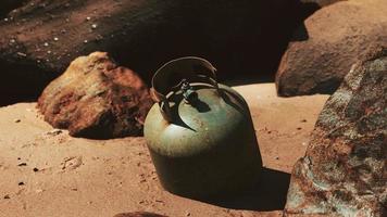 old cooking gas cylinder on sand beach photo