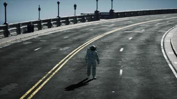 astronaut walks in the middle of a road photo