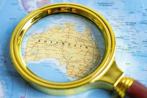 Bangkok, Thailand - January 20, 2022 Australia, Magnifying glass close up with colorful world map. photo