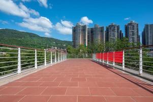 Under the blue sky and white clouds, a red brick road in the city leads to the distance photo