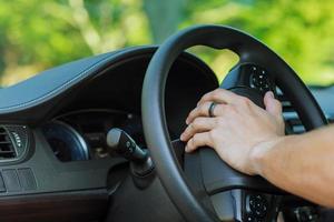 Man's hand on the steering wheel of a car photo