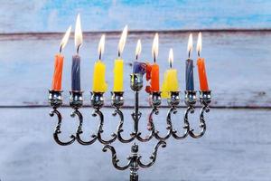 Hanukkah menorah with candles and silver dreidel. photo