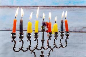 Hanukkah menorah with candles and silver dreidel. photo