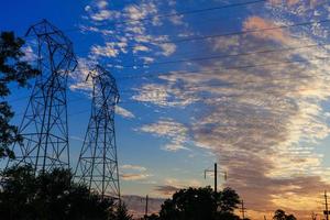 High voltage power pylons in sunset scene twilight photo