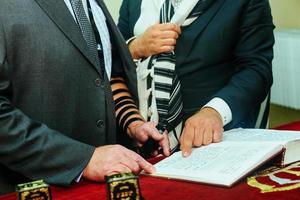 mano de niño leyendo el judío en bar mitzvah foto