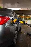 Pumping gasoline fuel in car at gas station. Car refueling fuel on petrol station. Service is filling gas or biodiesel into the tank. photo