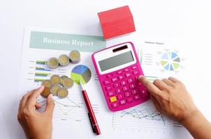 Hand touch calculator and keep coins with pen and red house for business finance concept backgrounds above photo