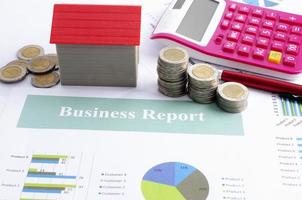 Close up of Red house and coin stack and calculator on business report backgrounds photo