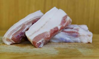 Raw pork belly with macro close up on wood cutting board photo